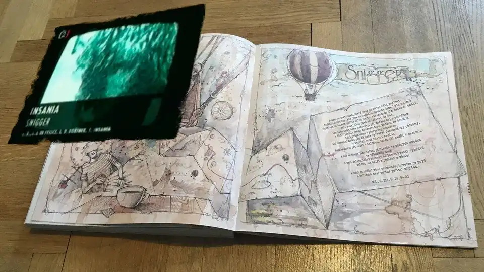 A watercolor spread with a hot-air balloon and the title “Snigger”, with the matching Insania track surfacing above the page as a green-tinted video panel.
