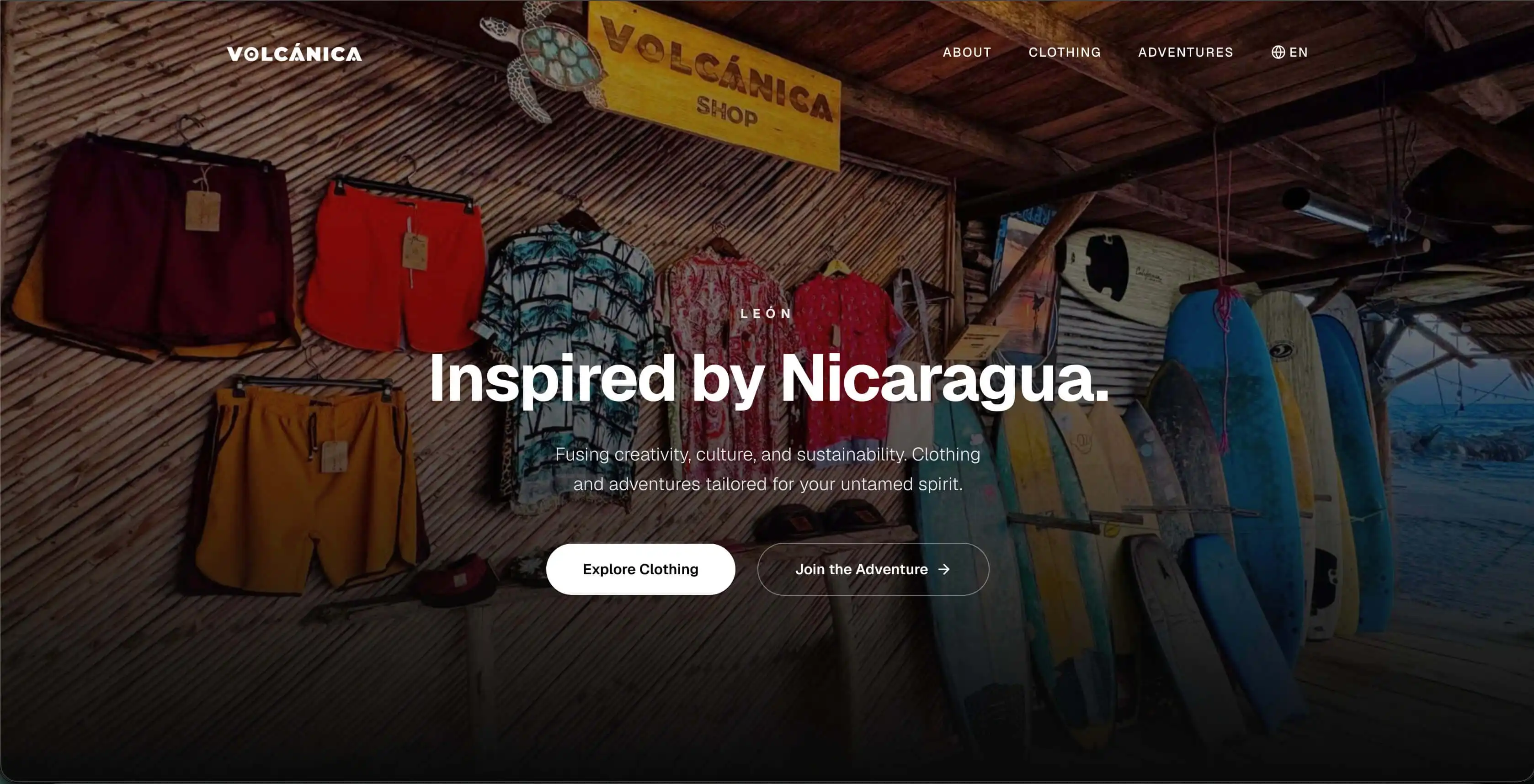 The Volcánica landing page: shirts and swim shorts hanging on the cane wall of a beach shack in León, a rack of surfboards to one side, under the line “Inspired by Nicaragua.”